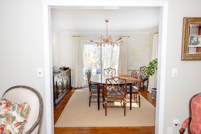 dining room featuring dark hardwood / wood-style flooring, a notable chandelier, and crown molding