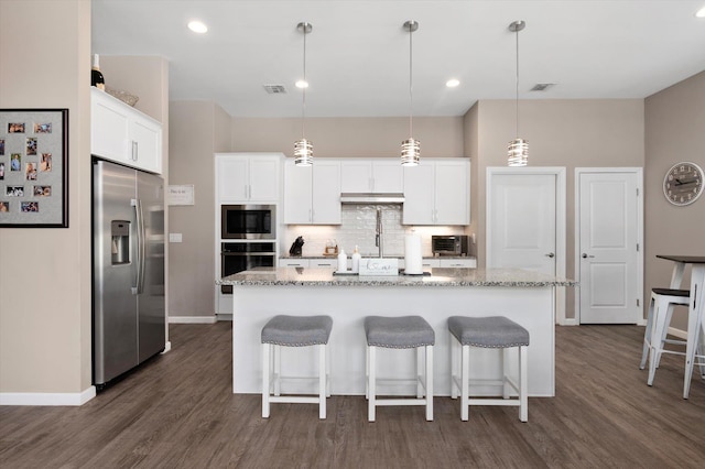 kitchen with black oven, an island with sink, white cabinets, hanging light fixtures, and stainless steel fridge with ice dispenser