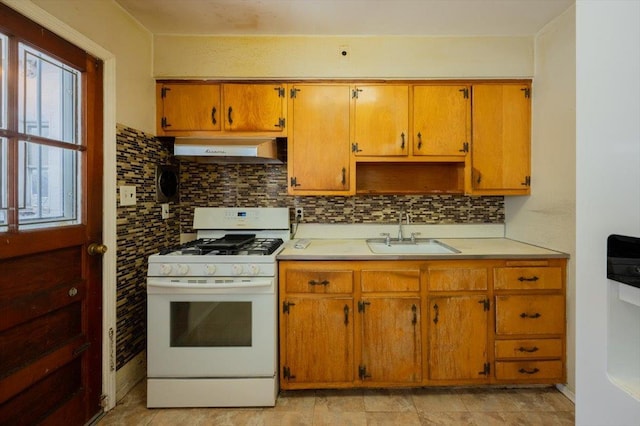 kitchen featuring white gas range, sink, and backsplash