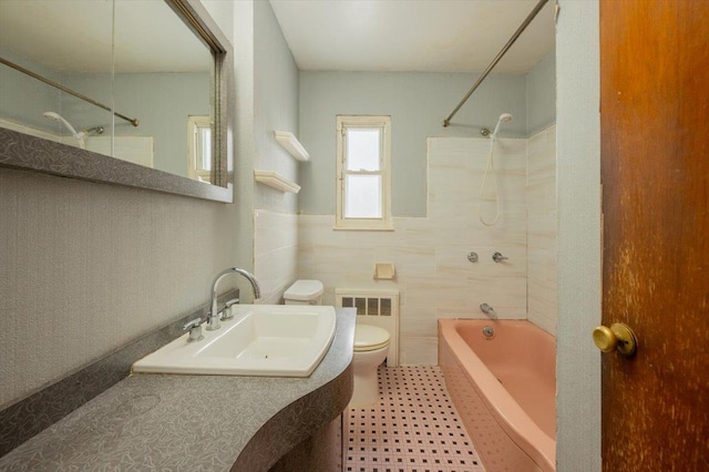 full bathroom with toilet, sink, shower / bathing tub combination, tile walls, and radiator