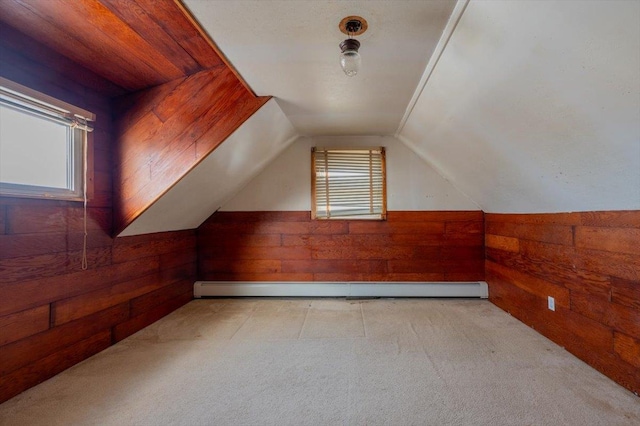 bonus room featuring a baseboard radiator, vaulted ceiling, light carpet, and wooden walls