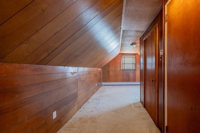 bonus room featuring lofted ceiling, light carpet, baseboard heating, and wood walls