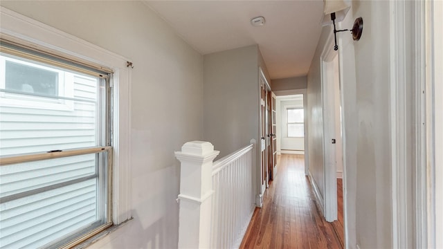 hall with an upstairs landing and wood finished floors