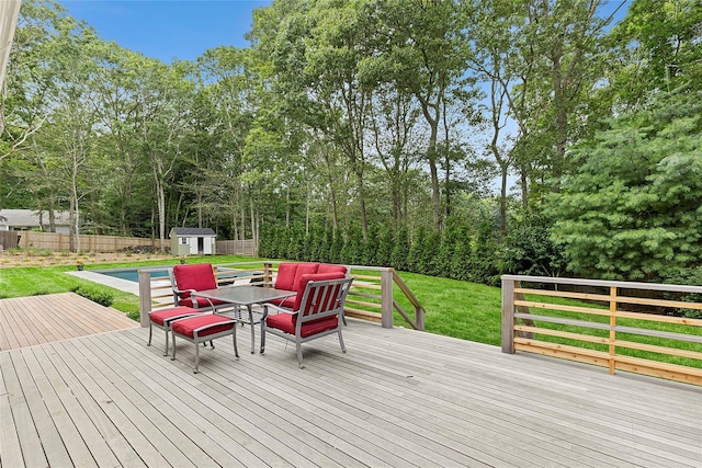 wooden terrace featuring a pool, a yard, and a storage unit