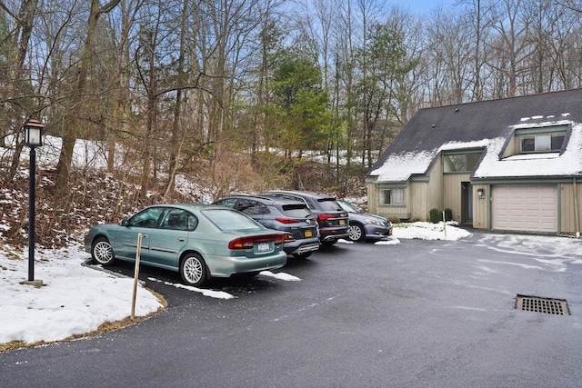 snow covered parking with a garage