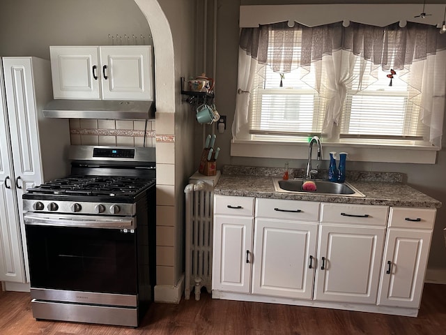 kitchen with radiator, sink, white cabinets, dark hardwood / wood-style flooring, and gas stove