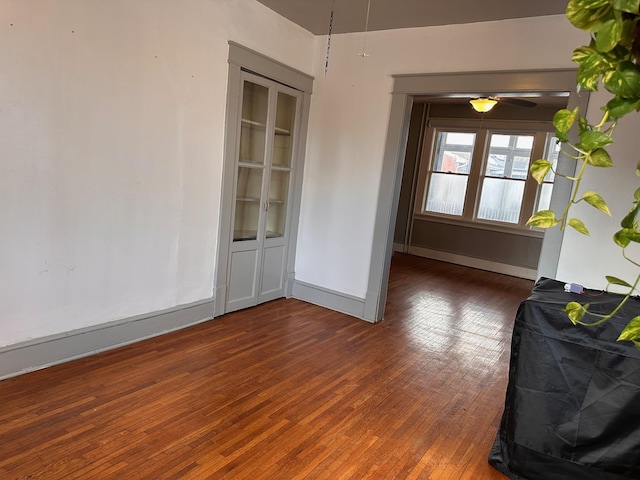 spare room with baseboards and dark wood finished floors