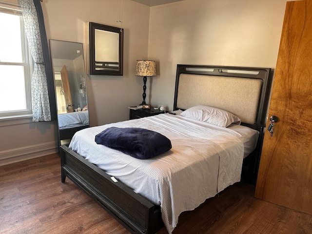 bedroom featuring dark wood-style floors and baseboards