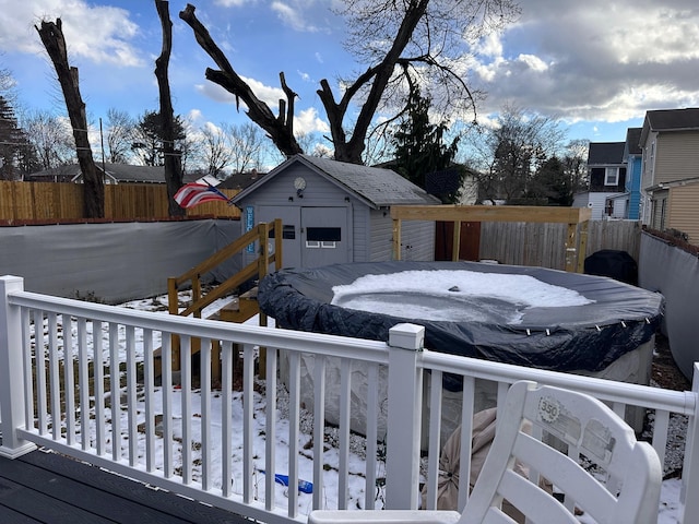 yard layered in snow with an outbuilding, fence private yard, and a wooden deck