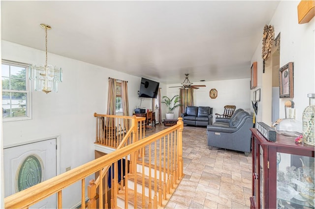 living room featuring ceiling fan with notable chandelier