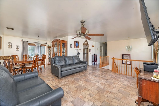 living room featuring ceiling fan with notable chandelier