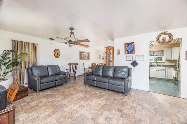 living room featuring ceiling fan and sink