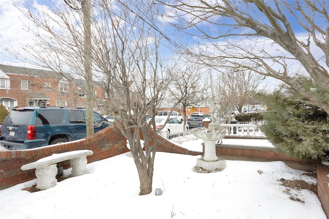 yard covered in snow with a residential view