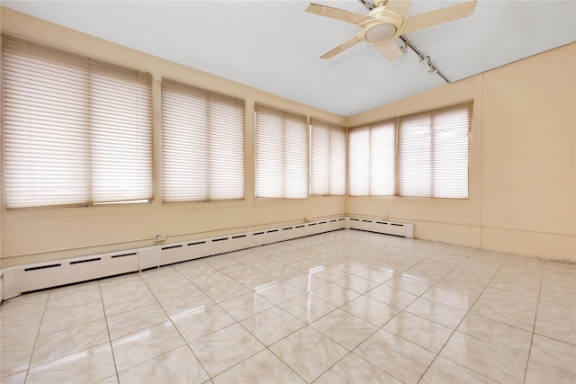 spare room featuring a baseboard heating unit, a ceiling fan, and light tile patterned flooring