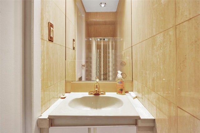 full bathroom featuring a shower with curtain, tile walls, and vanity