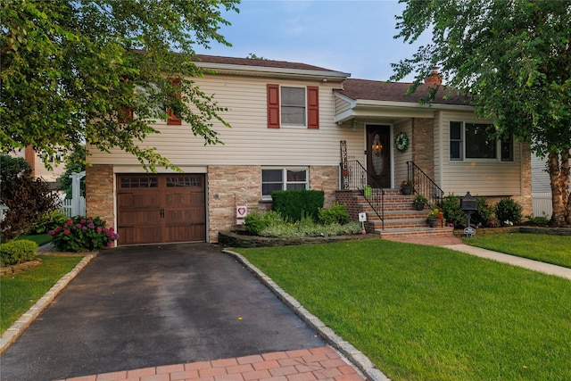 split level home featuring a garage and a front lawn