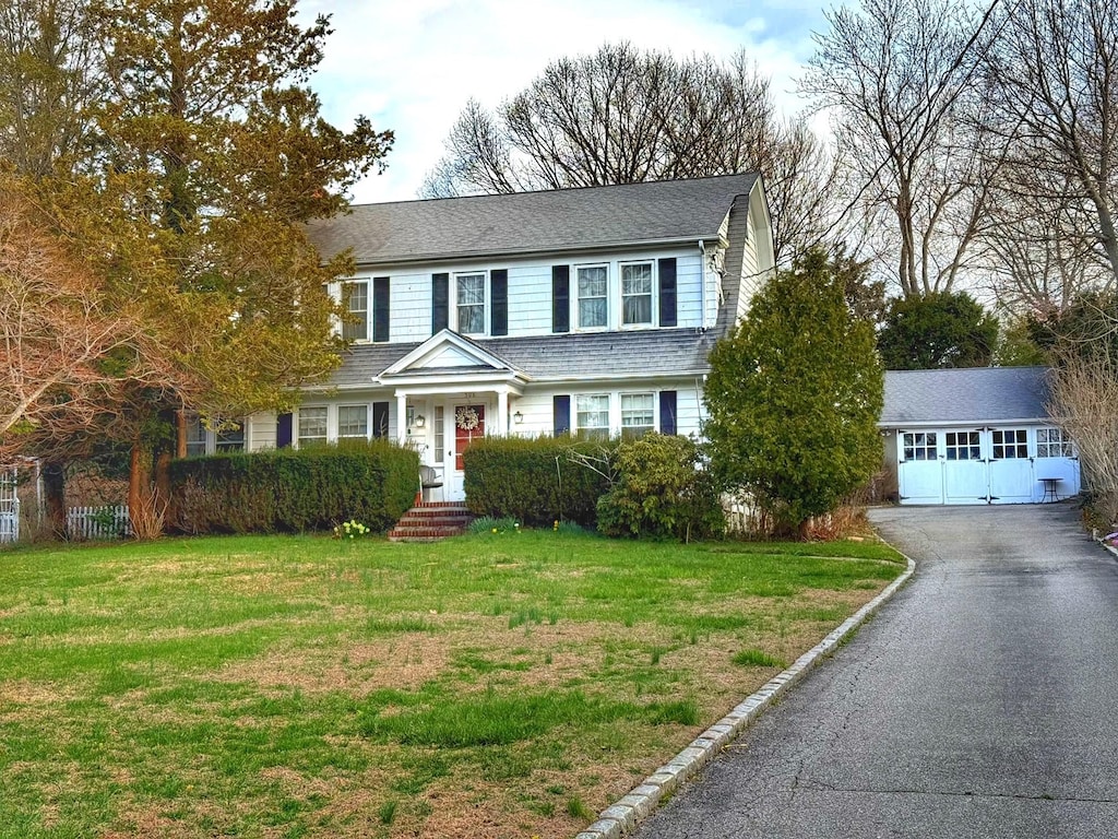 508 W Broadway Prt, Jefferson, NY 11777 - view of front of house featuring aphalt driveway, a shingled roof, an outdoor structure, and a front yard