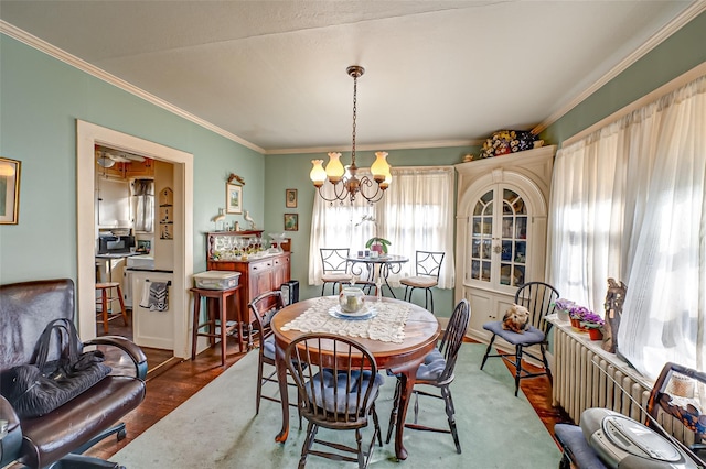 dining room featuring radiator, ornamental molding, dark wood-type flooring, and a chandelier