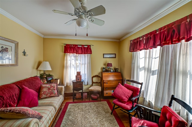 living area featuring a wealth of natural light, wood finished floors, ceiling fan, and ornamental molding
