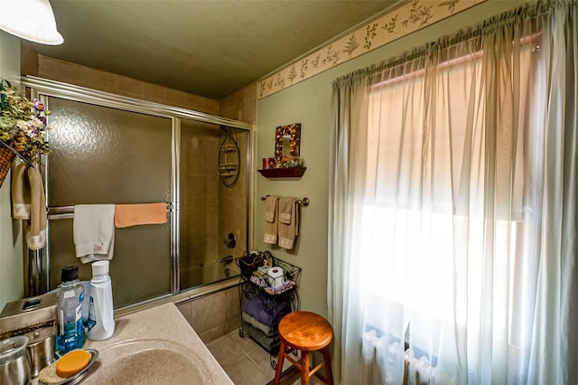 bathroom with tile patterned flooring, shower / bath combination with glass door, and vanity