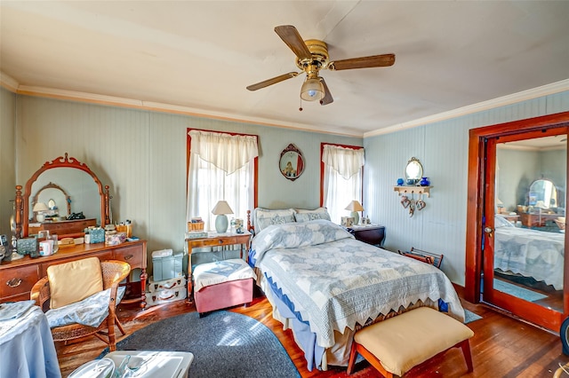 bedroom featuring crown molding, wood finished floors, and a ceiling fan