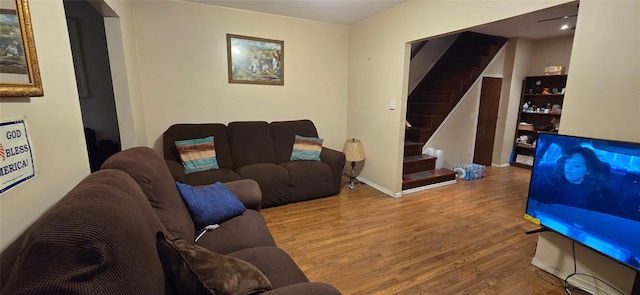 living area featuring stairway, baseboards, and wood finished floors