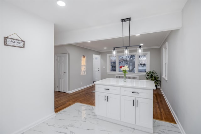 kitchen with white cabinetry, hanging light fixtures, ornamental molding, and a kitchen island