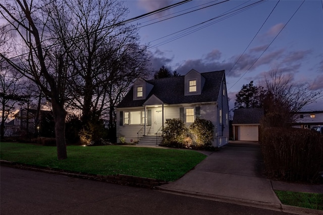 cape cod home with an outbuilding, a garage, and a yard