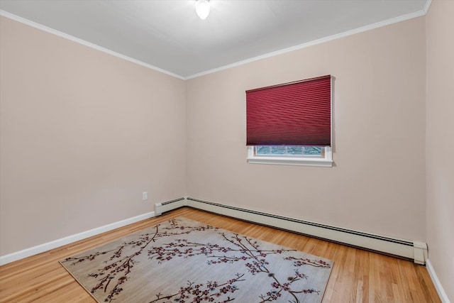 spare room with ornamental molding, hardwood / wood-style floors, and baseboard heating