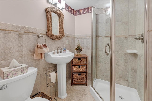 bathroom with toilet, an enclosed shower, sink, tile walls, and tile patterned flooring