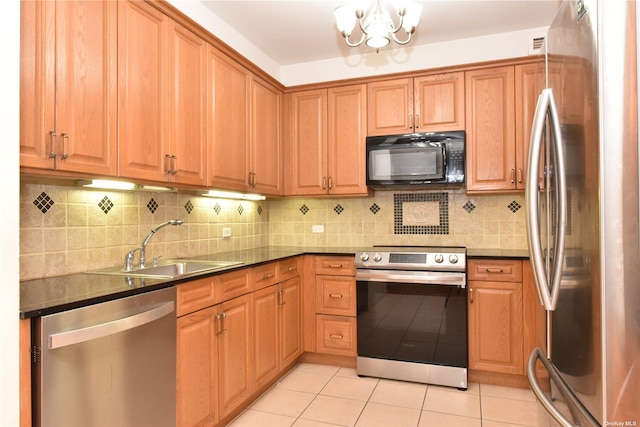 kitchen featuring sink, light tile patterned floors, appliances with stainless steel finishes, tasteful backsplash, and a notable chandelier