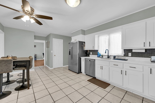 kitchen with light tile patterned floors, stainless steel appliances, light countertops, decorative backsplash, and white cabinetry