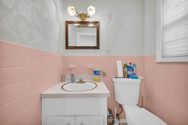 half bath featuring wainscoting, vanity, and toilet