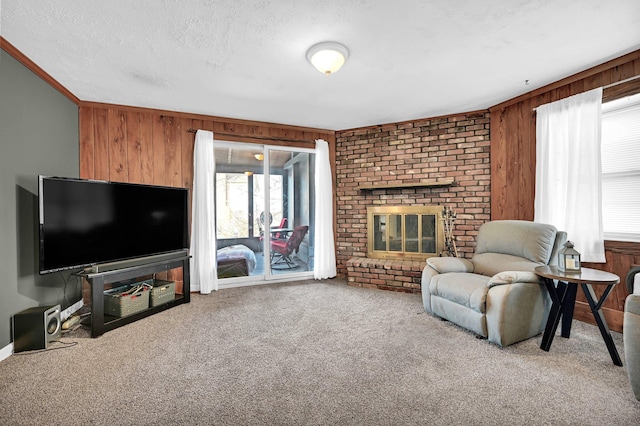 living area featuring carpet floors, a fireplace, crown molding, wood walls, and a textured ceiling