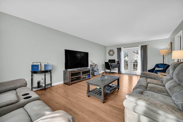 living area with baseboards, french doors, and light wood-style floors