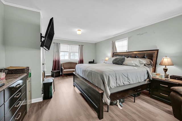 bedroom featuring baseboards, ornamental molding, and wood finished floors