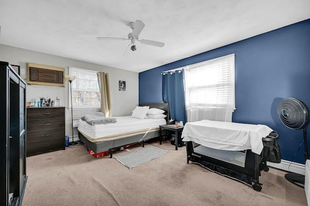 bedroom with ceiling fan, baseboards, and light colored carpet