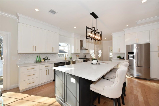 kitchen with hanging light fixtures, stainless steel refrigerator with ice dispenser, a kitchen island, and white cabinets