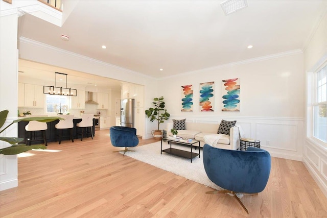 living room featuring ornamental molding and light hardwood / wood-style floors