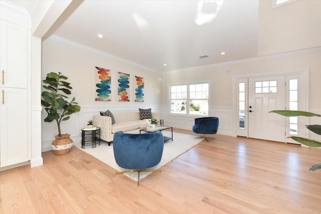 living room with ornamental molding and light hardwood / wood-style floors