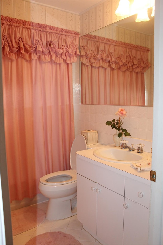 bathroom featuring tile patterned flooring, vanity, toilet, and tile walls