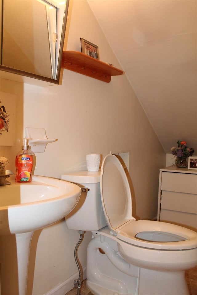 bathroom featuring vaulted ceiling and toilet