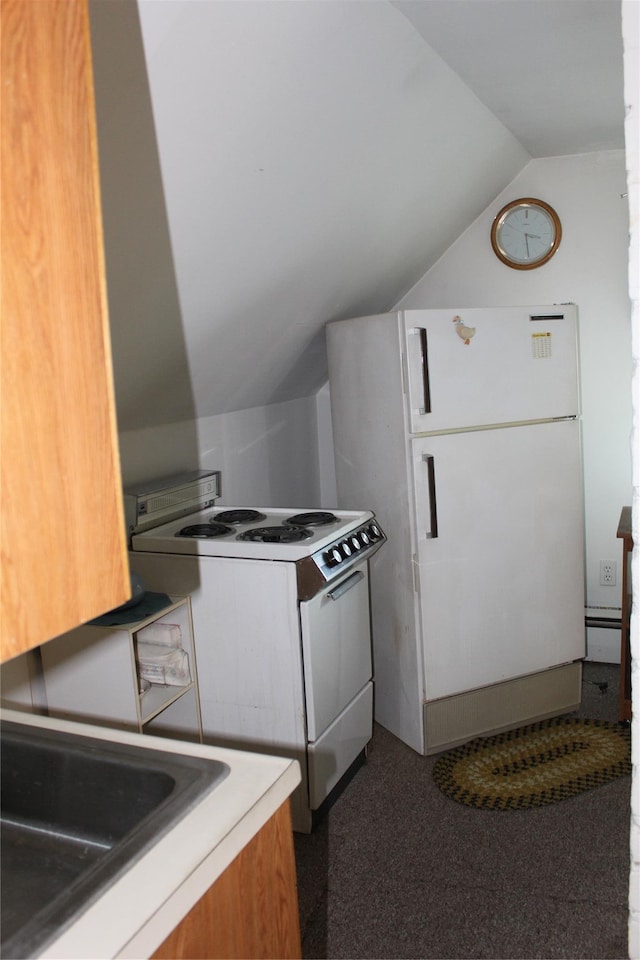 kitchen with white appliances, lofted ceiling, a baseboard heating unit, and dark colored carpet