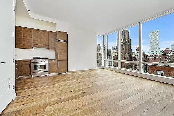 kitchen featuring high end appliances, floor to ceiling windows, and light hardwood / wood-style flooring