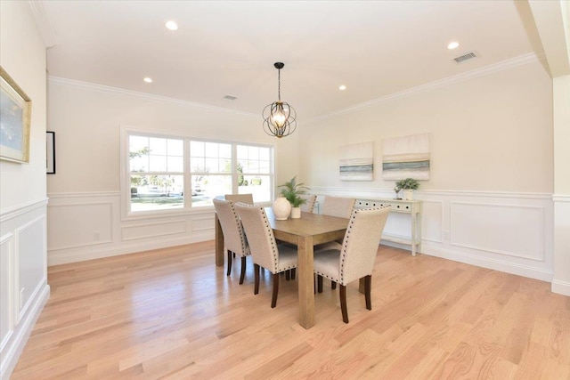 dining room featuring crown molding, a notable chandelier, and light hardwood / wood-style floors