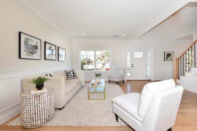 living room with ornamental molding and light wood-type flooring