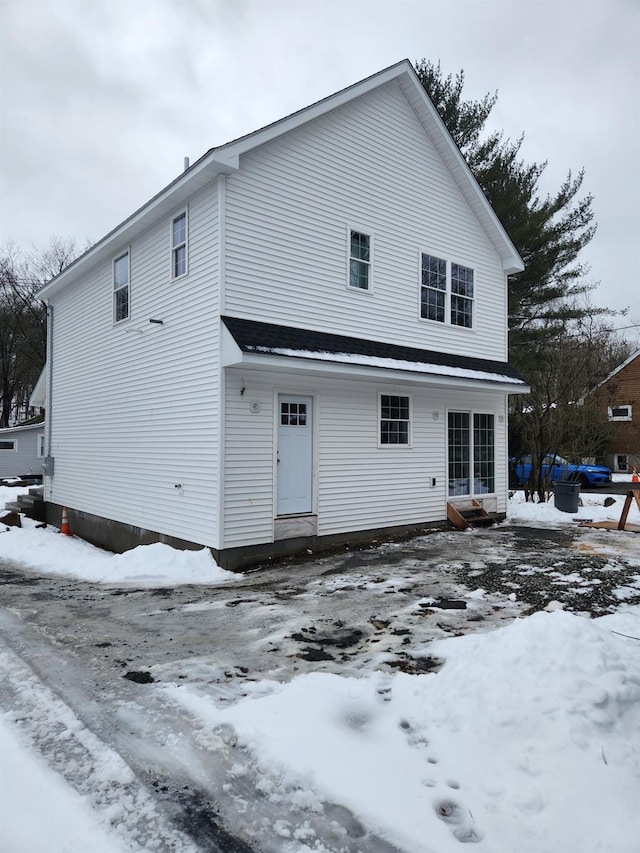 snow covered rear of property with entry steps