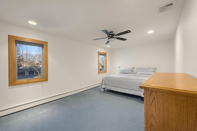 bedroom with ceiling fan and a baseboard heating unit