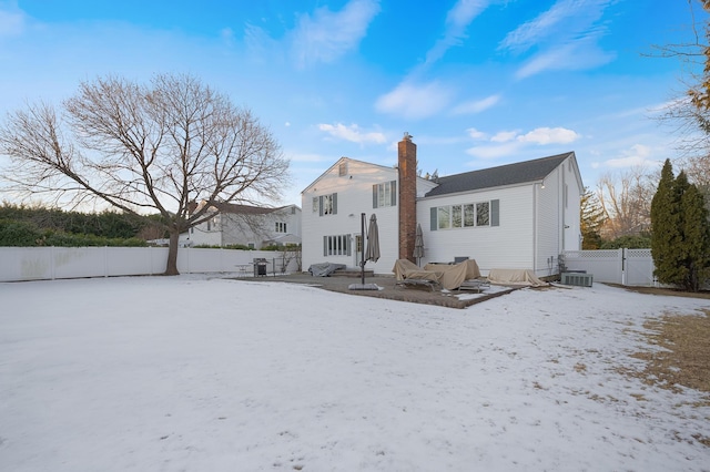 snow covered house featuring cooling unit