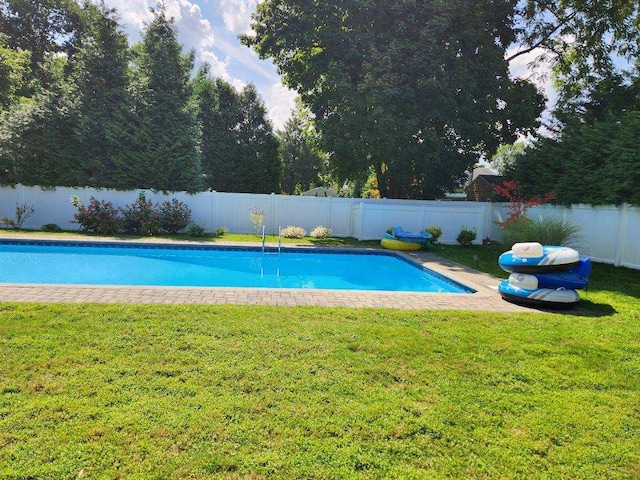 view of swimming pool with a yard